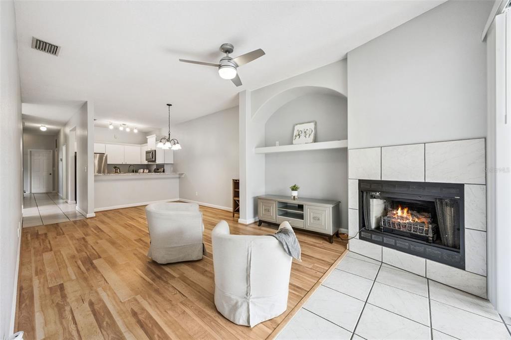 A living room features hardwood floors, a tiled fireplace, and an arched wall niche — 2202 GARDEN LAKE DRIVE, WINTER HAVEN, FL