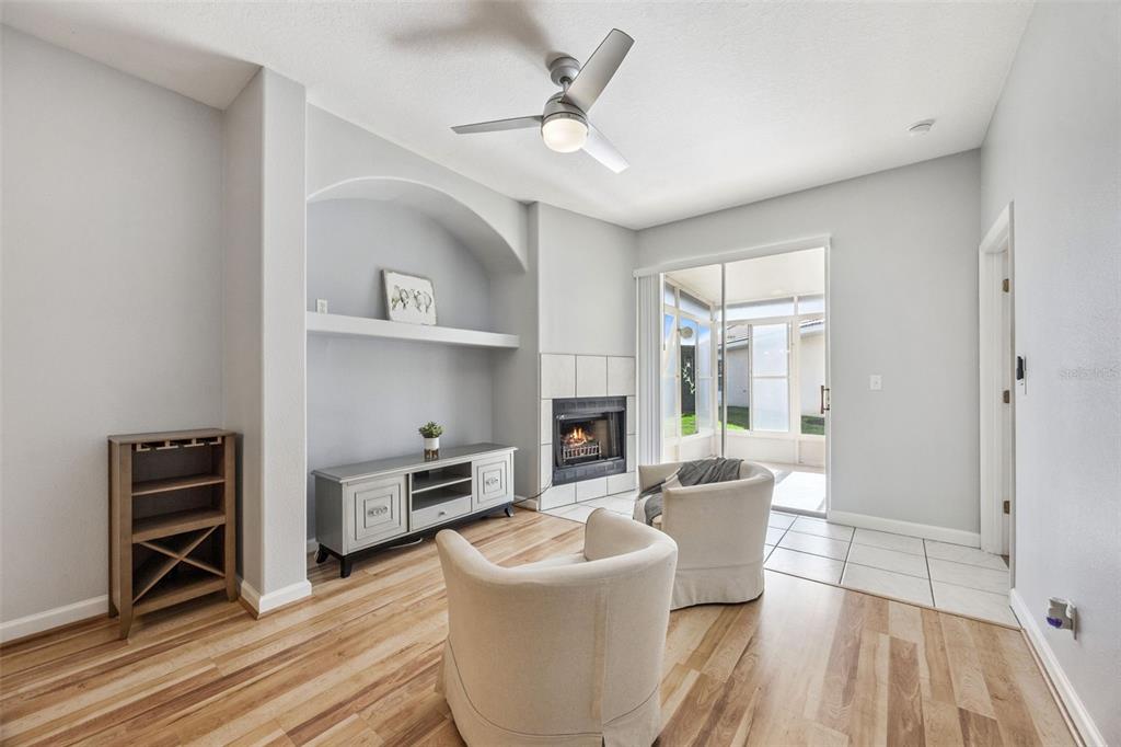 A living room with wood floors, a fireplace, a built-in niche, and a sliding glass door — 2202 GARDEN LAKE DRIVE, WINTER HAVEN, FL