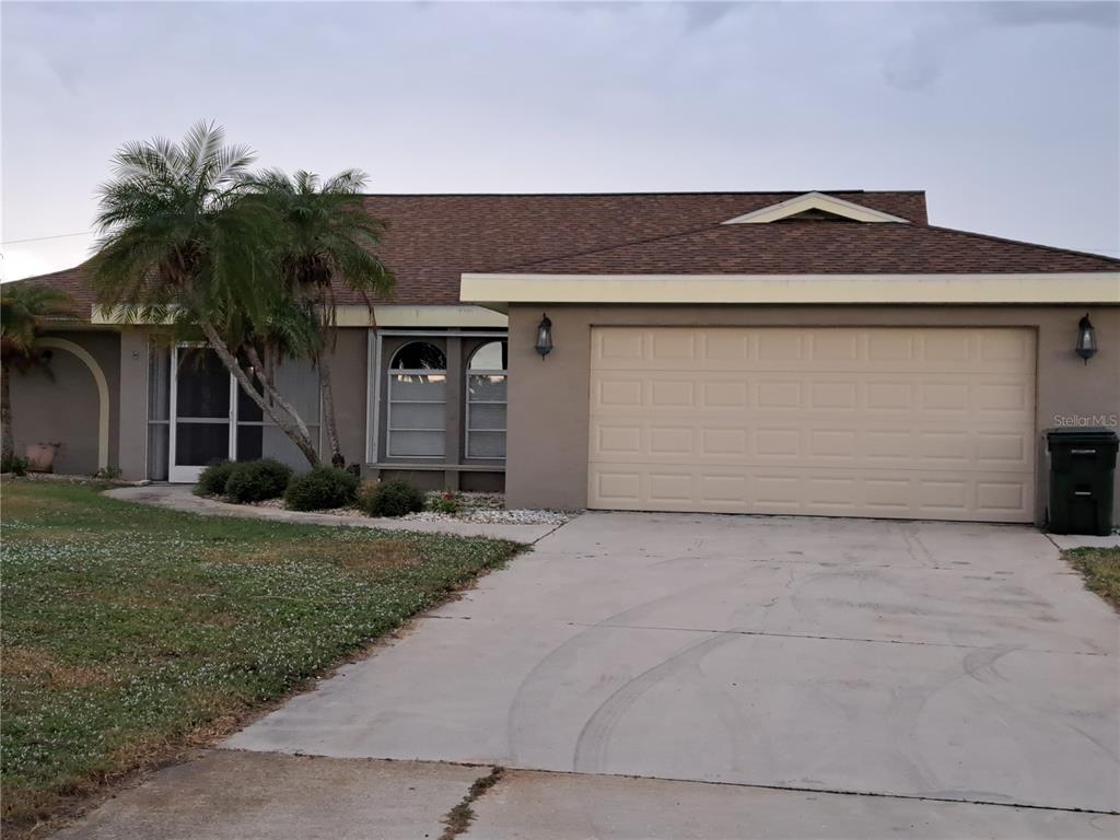 A single-story house with a beige exterior, a two-car garage, and a palm tree — 26 CLINTWOOD AVENUE, ENGLEWOOD, FL