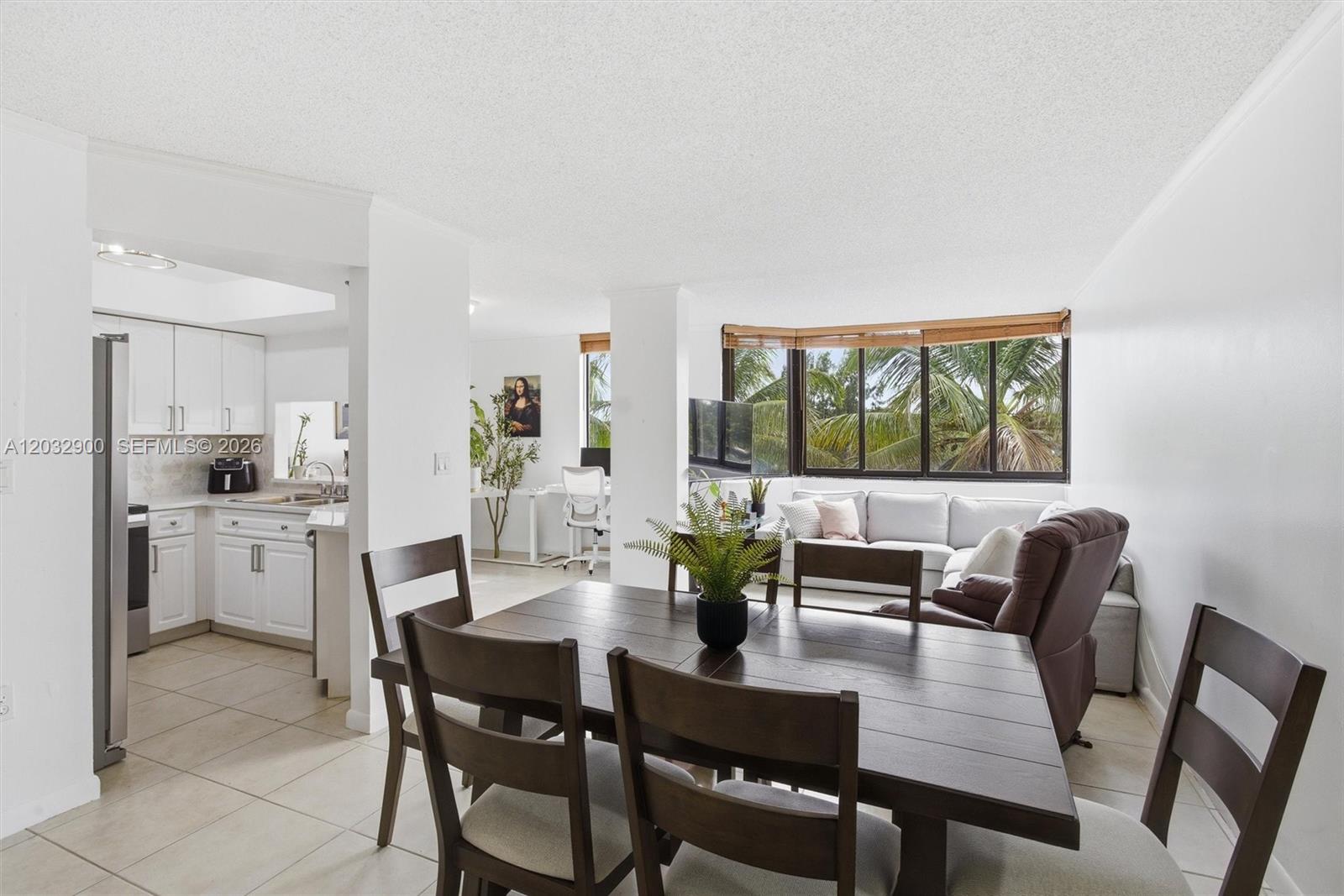 A dining area with a dark wood table sits in front of a living room — 8335 SW 152nd Ave # 411, Miami FL 33193, MIAMI, FL