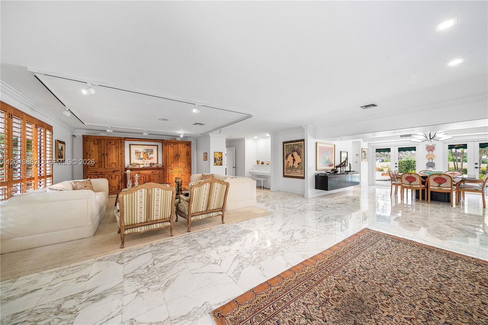 A spacious living and dining area features marble floors, white walls, and wood cabinetry — 4301 Sanders St, Hollywood FL 33021, HOLLYWOOD, FL