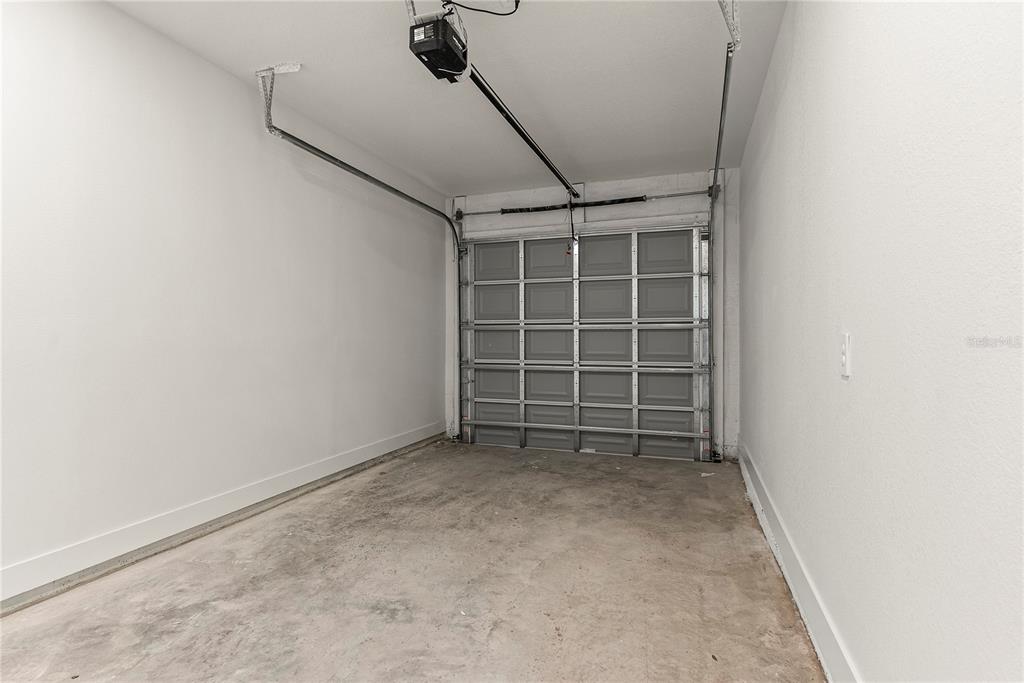 An empty one-car garage with white walls, a concrete floor, and a sectional door — 2808 N 29TH STREET UNIT 2, TAMPA, FL