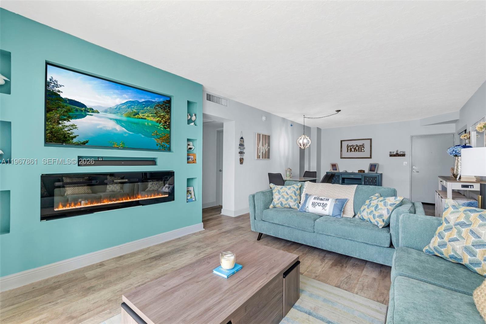 A living room features a teal accent wall with a built-in television and fireplace — 3000 S Ocean Dr # 1122, Hollywood FL 33019, HOLLYWOOD, FL