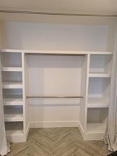 A white custom closet features built-in shelving units on both sides and a hanging rod — 189 Seville # 189, Delray Beach FL 33446, DELRAY BEACH, FL