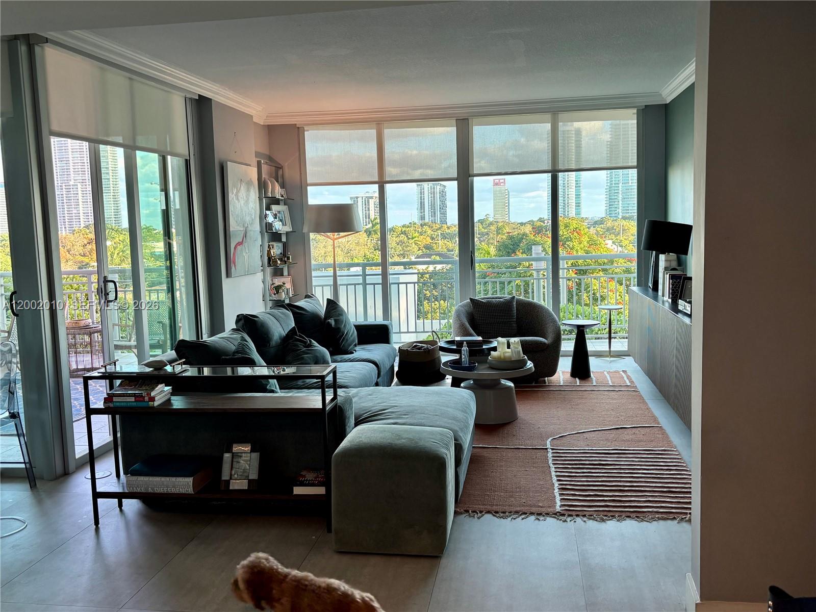 A living room with a sectional sofa, area rug, and floor-to-ceiling windows overlooking city buildings — 2021 SW 3rd Ave # 605, Miami FL 33129, MIAMI, FL