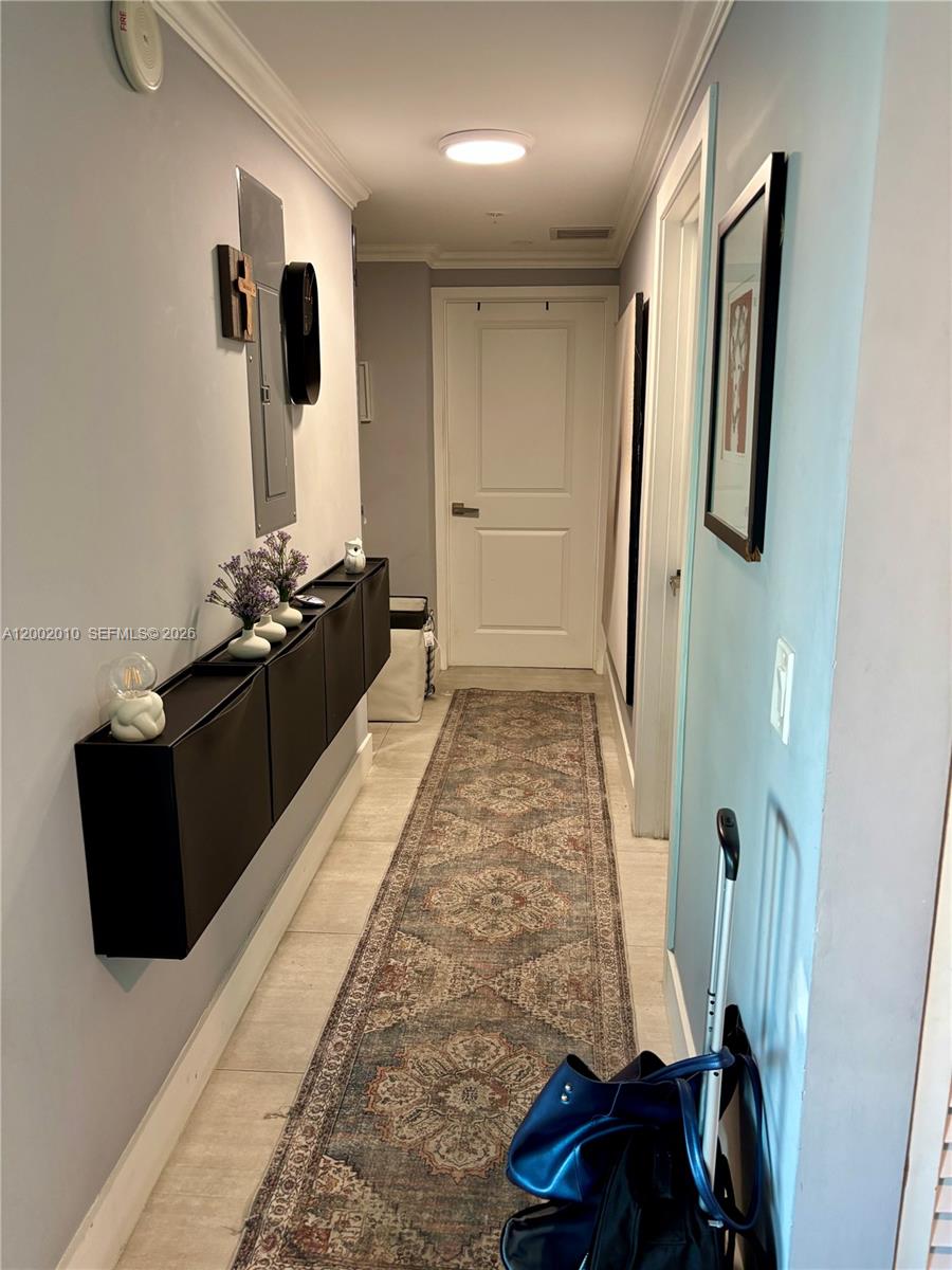 A narrow hallway features a patterned runner rug, wall-mounted black storage cabinets, and light-colored walls — 2021 SW 3rd Ave # 605, Miami FL 33129, MIAMI, FL