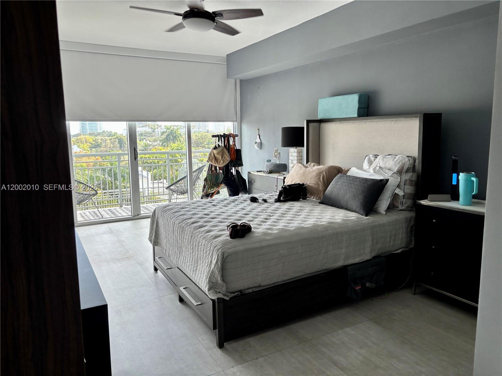 A bedroom features a bed with a tall headboard, tile flooring, and a balcony view — 2021 SW 3rd Ave # 605, Miami FL 33129, MIAMI, FL