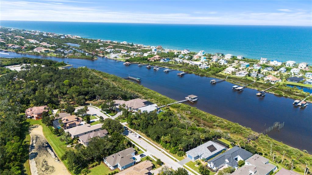 An aerial view shows a residential neighborhood situated along a river leading to the ocean — 62 N RIVERWALK DRIVE, PALM COAST, FL