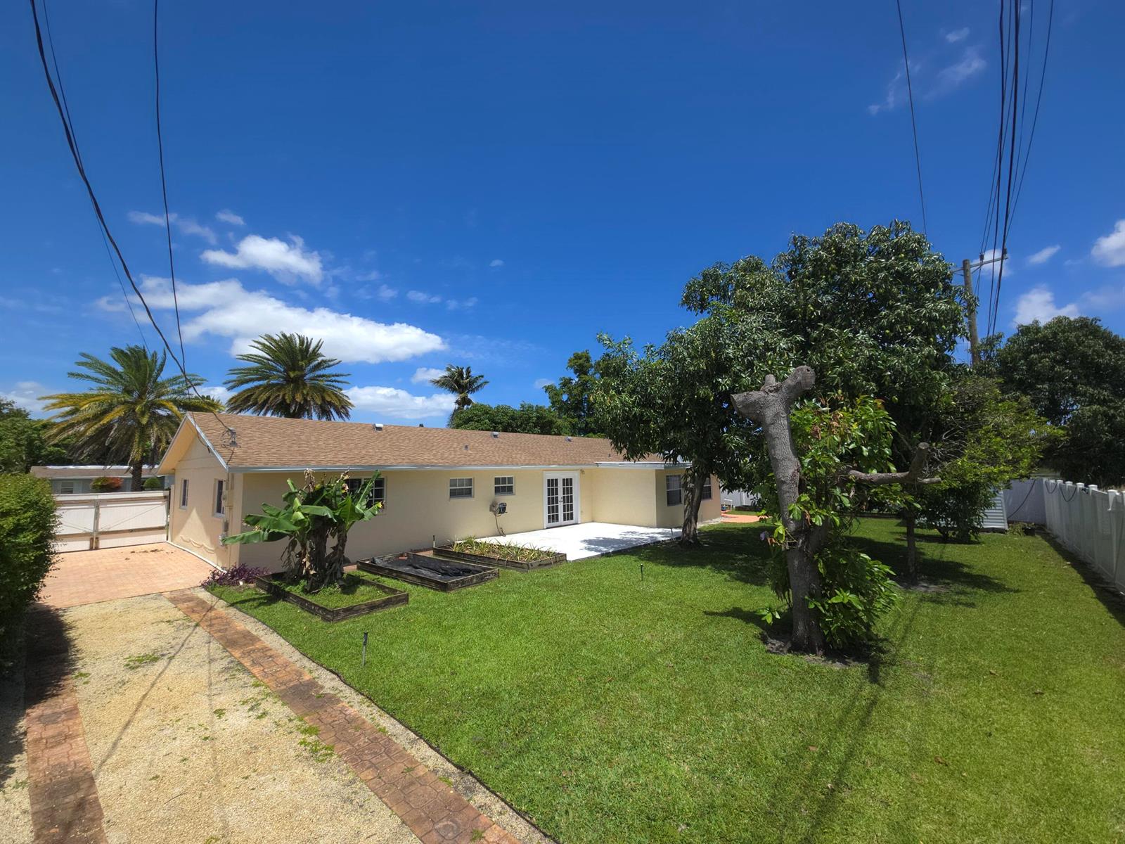 A single-story yellow house with a brown roof, a grassy yard, and several trees — 4554 Franwood Drive, Delray Beach FL 33445, DELRAY BEACH, FL