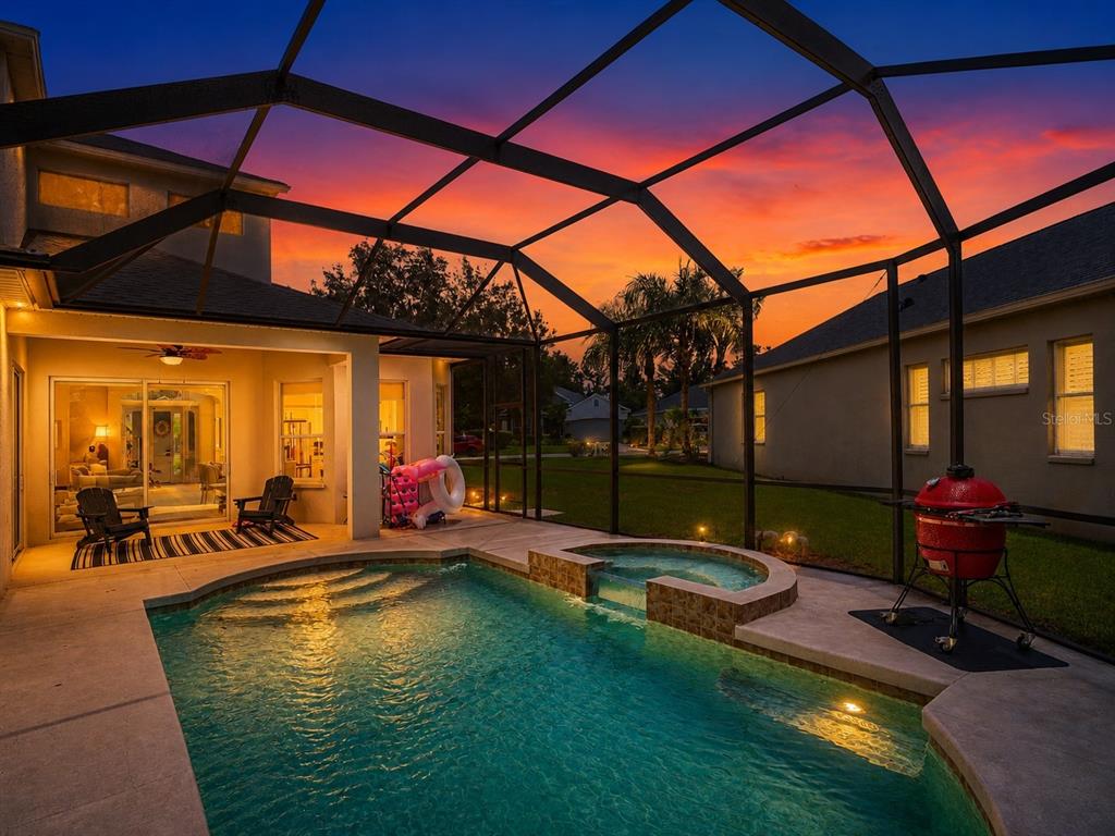 A screened-in patio features a swimming pool, a hot tub, and a red charcoal grill — 14146 CATTLE EGRET PL, LAKEWOOD RANCH, FL