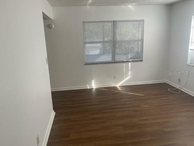 An empty room with white walls, wood-look flooring, and a window with horizontal blinds — 3800 18TH AVENUE S UNIT 4, ST PETERSBURG, FL