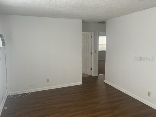 An empty room with white walls, wood-look flooring, and a doorway leading to another room — 3800 18TH AVENUE S UNIT 4, ST PETERSBURG, FL