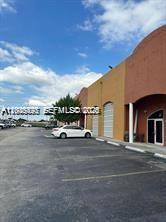 A white car is parked in front of a commercial building with arched entrances — 2980 W 82th St # 5, Hialeah FL 33018, HIALEAH, FL