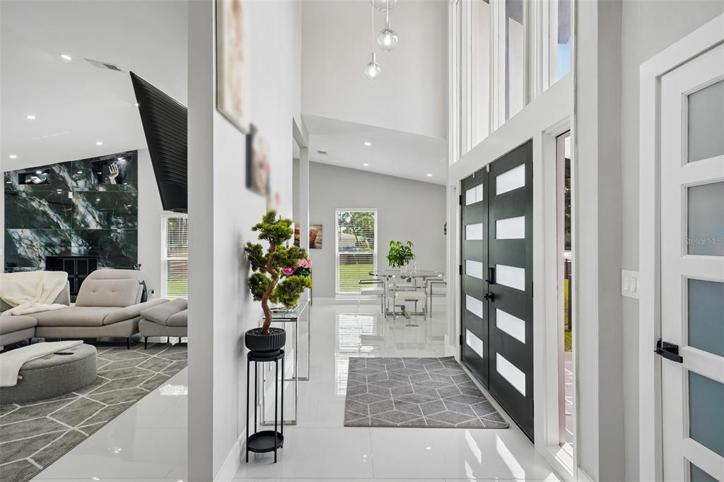 A bright entryway features white tile floors, a modern double door, and a high ceiling — 5201 HUNTINGTON STREET NE, ST PETERSBURG, FL