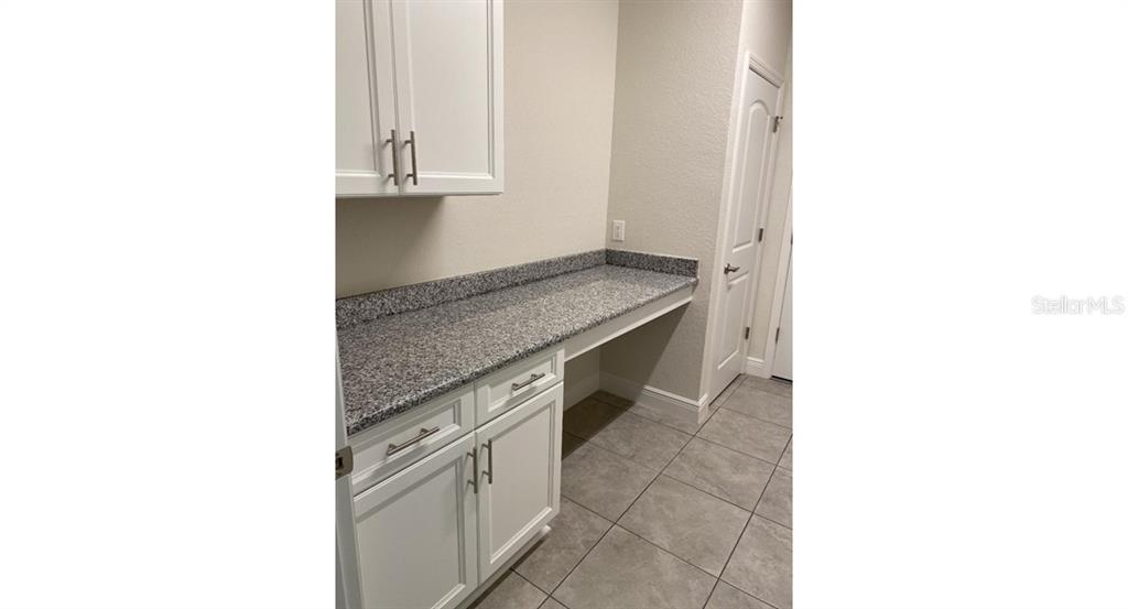 A built-in desk area features white cabinetry, a granite countertop, and tile flooring — 4501 CARRIZAL TERRACE, NORTH PORT, FL