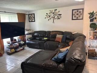 A living room features a large black leather sectional sofa, a television, and wall decor — 1370 NW 54th Terrace, Lauderhill FL 33313, LAUDERHILL, FL
