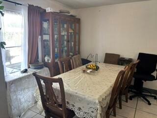 A dining room features a wooden hutch, a table with a lace tablecloth, and chairs — 1370 NW 54th Terrace, Lauderhill FL 33313, LAUDERHILL, FL