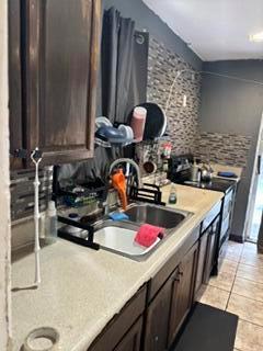 A kitchen features dark wood cabinets, a stainless steel sink, and a tiled backsplash — 1370 NW 54th Terrace, Lauderhill FL 33313, LAUDERHILL, FL
