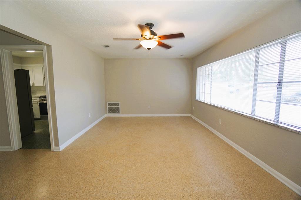 An empty room with beige walls, a ceiling fan, and large windows with horizontal blinds — 206 S WESTSHORE BOULEVARD, TAMPA, FL