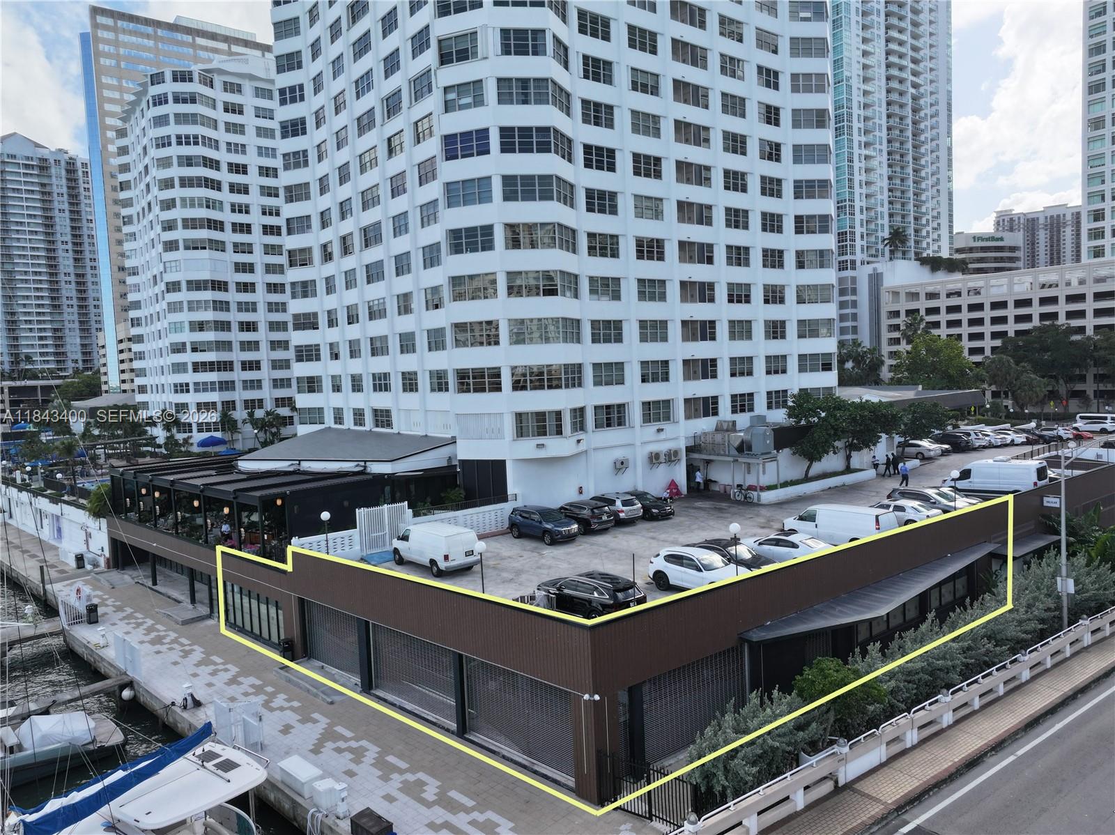 An elevated view shows a commercial building with a rooftop parking lot and waterfront access — 801 Brickell Bay Dr, Miami FL 33131, MIAMI, FL