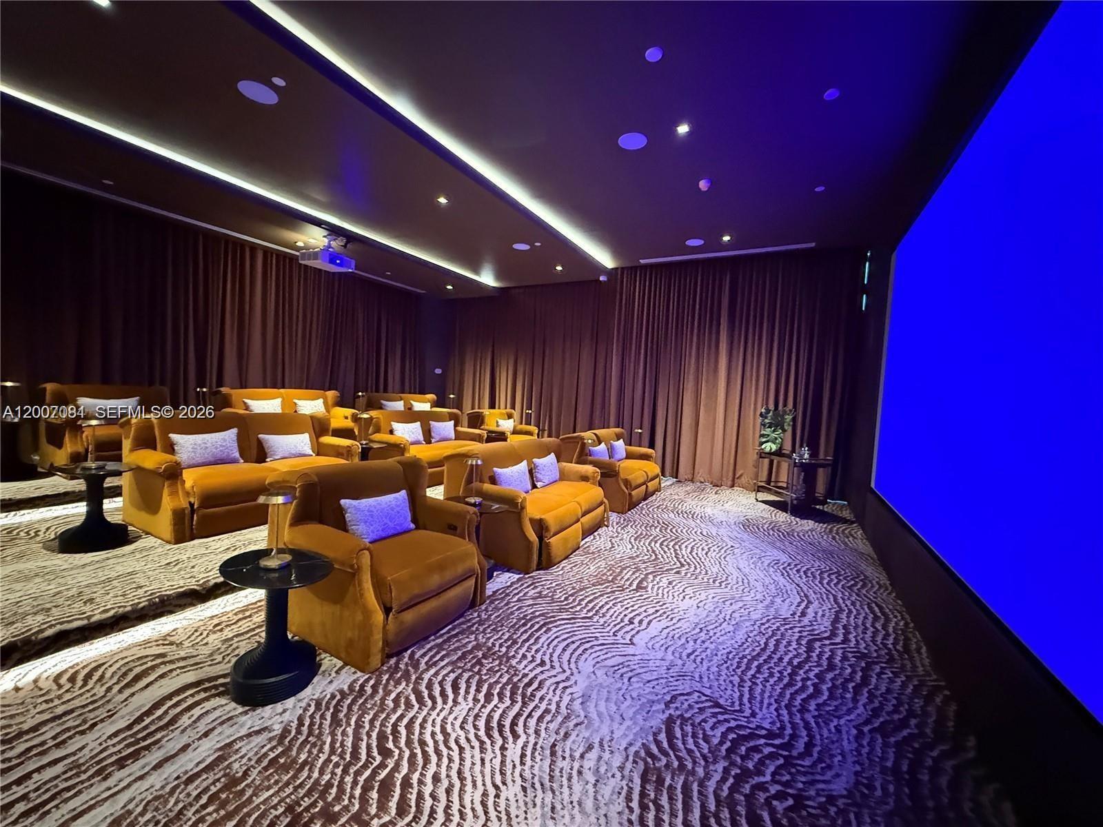 A home theater features tiered rows of orange velvet seating and a large projection screen — 77 SE 5th Street # 1014, Miami FL 33131, MIAMI, FL