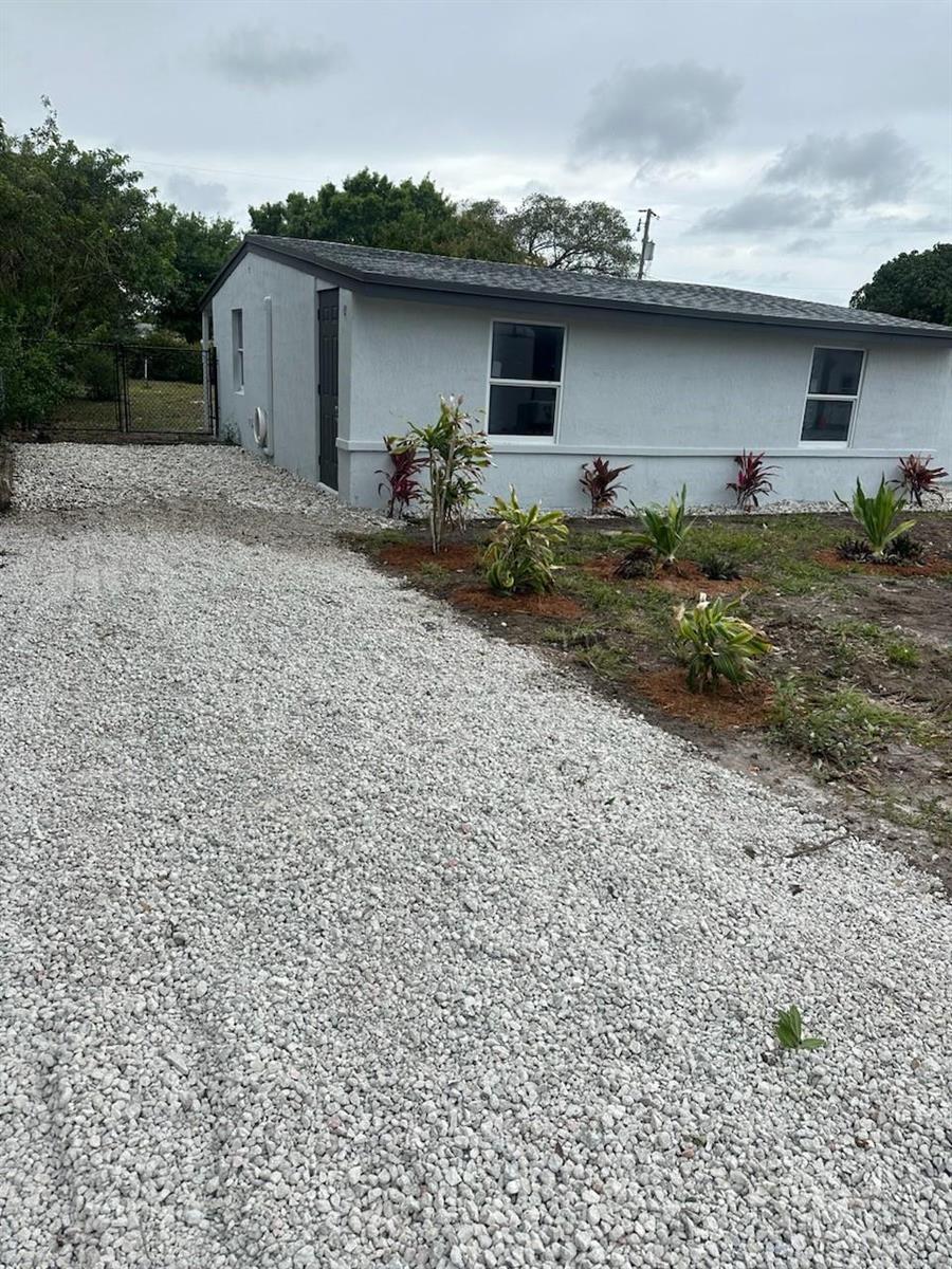 A gray house with a gravel driveway and small plants in the front yard — 4365 27th Avenue, Vero Beach FL 32967, VERO BEACH, FL