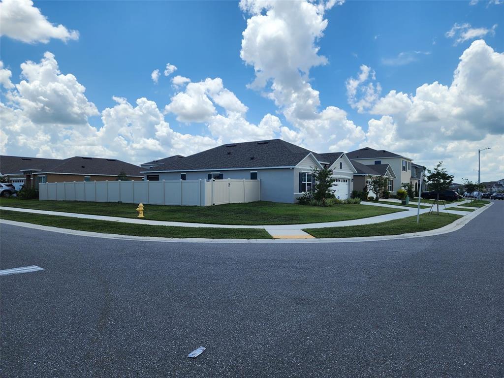 A corner lot features a single-story house with a tan vinyl fence and a fire hydrant — 1051 GRIFFON AVENUE, LAKE ALFRED, FL