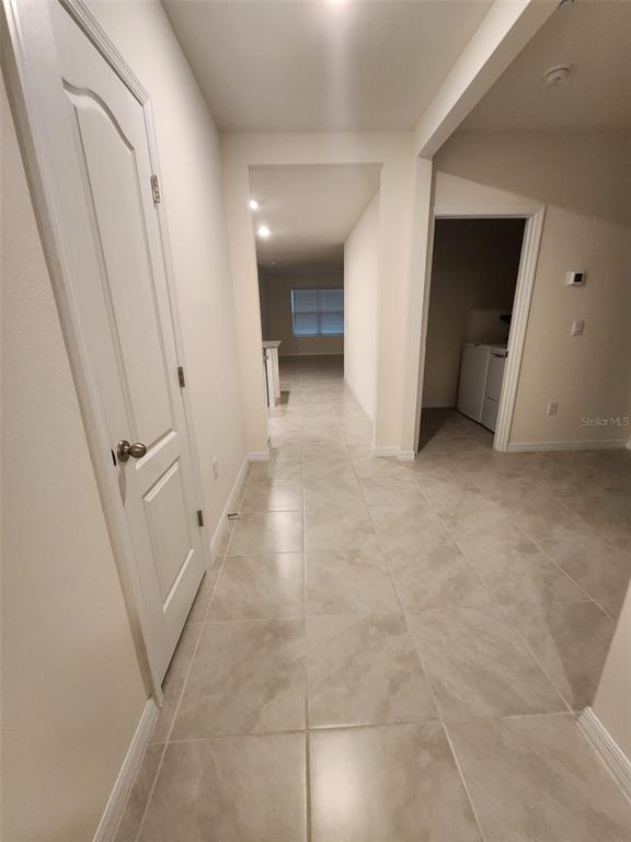 A tiled hallway leads to an open living area with a laundry room to the right — 1051 GRIFFON AVENUE, LAKE ALFRED, FL