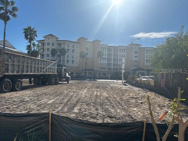 A vacant dirt lot sits in front of a large multi-story apartment building — 15227 GULF BOULEVARD, MADEIRA BEACH, FL