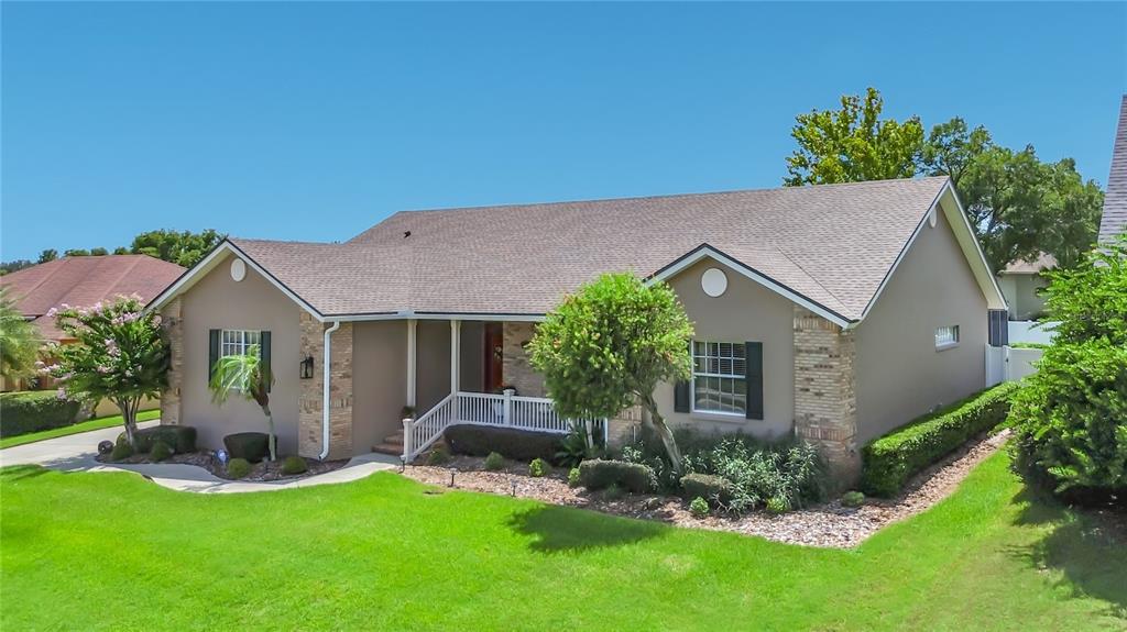 A single-story house with a tan exterior, brick accents, and a front porch — 1953 VIEWPOINT LANDINGS ROAD, LAKELAND, FL