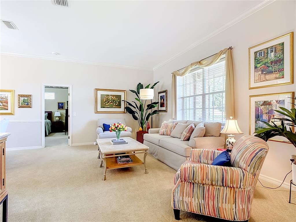 A living room features a beige sofa, a striped armchair, and a coffee table — 1953 VIEWPOINT LANDINGS ROAD, LAKELAND, FL