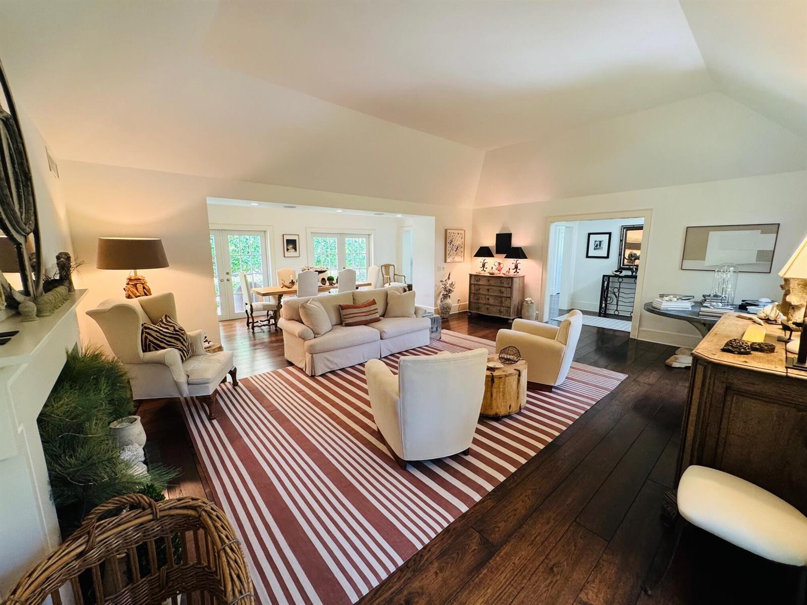 A spacious living room with vaulted ceilings, hardwood floors, and a striped area rug — 6880 N Ocean Boulevard # 22, Ocean Ridge FL 33435, OCEAN RIDGE, FL