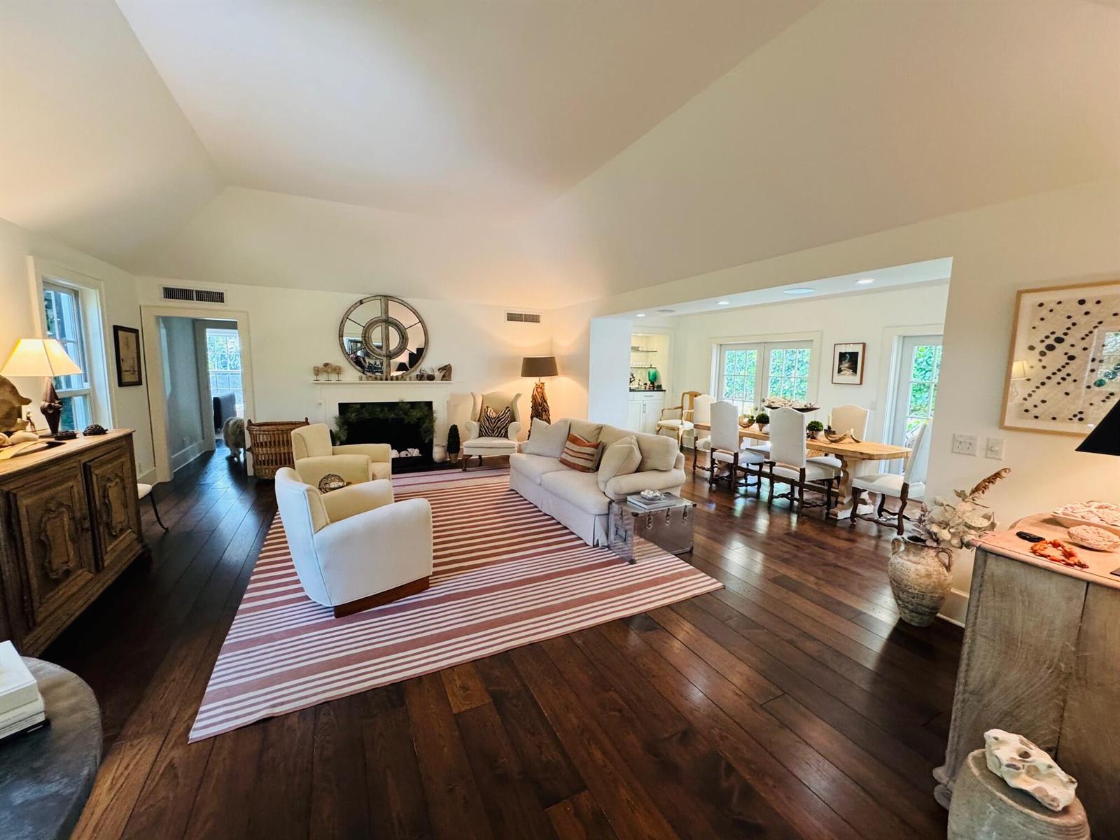 A spacious living and dining area with hardwood floors, a fireplace, and vaulted ceilings — 6880 N Ocean Boulevard # 22, Ocean Ridge FL 33435, OCEAN RIDGE, FL