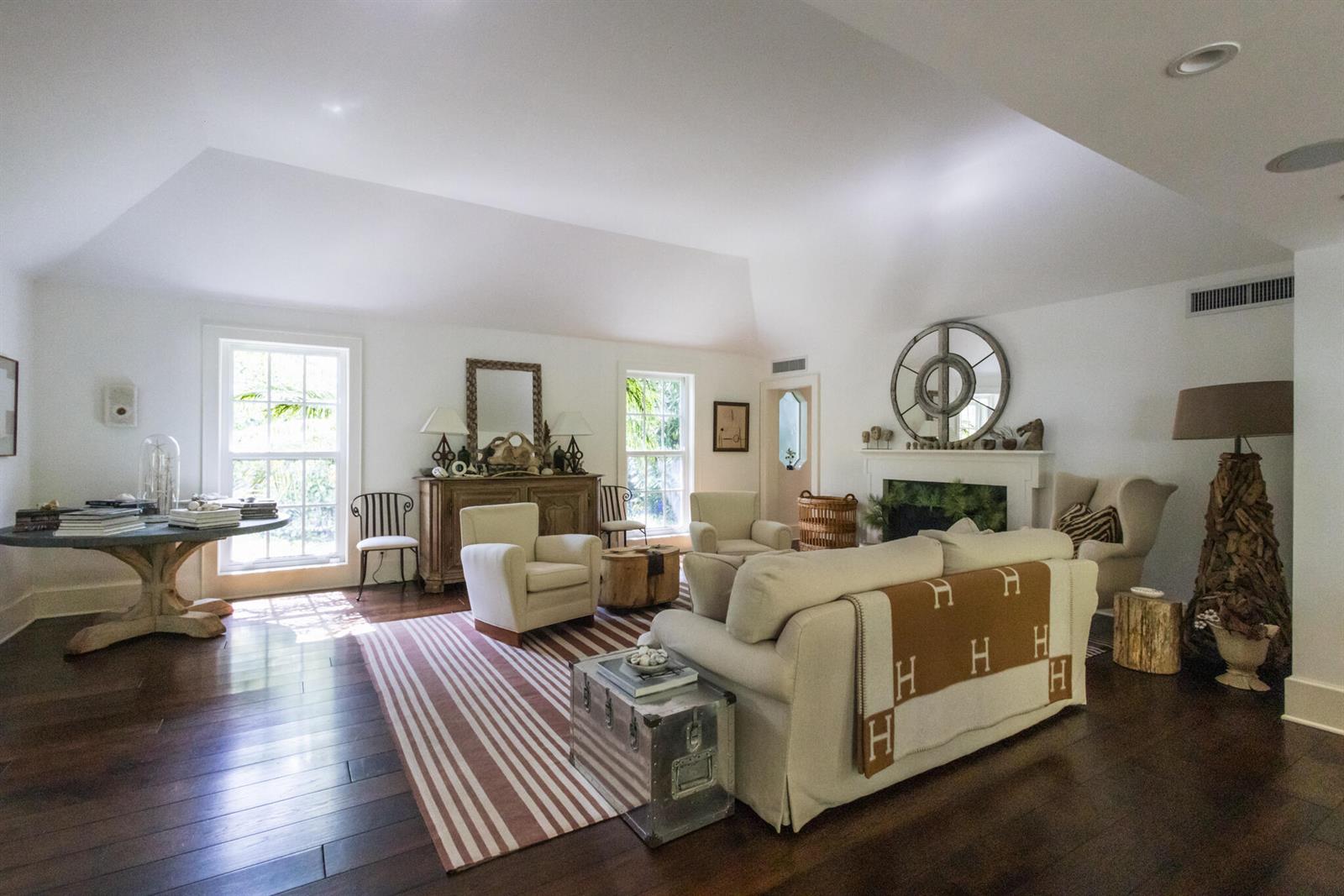 A spacious living room with white walls, a fireplace, hardwood floors, and neutral furniture — 6880 N Ocean Boulevard # 22, Ocean Ridge FL 33435, OCEAN RIDGE, FL