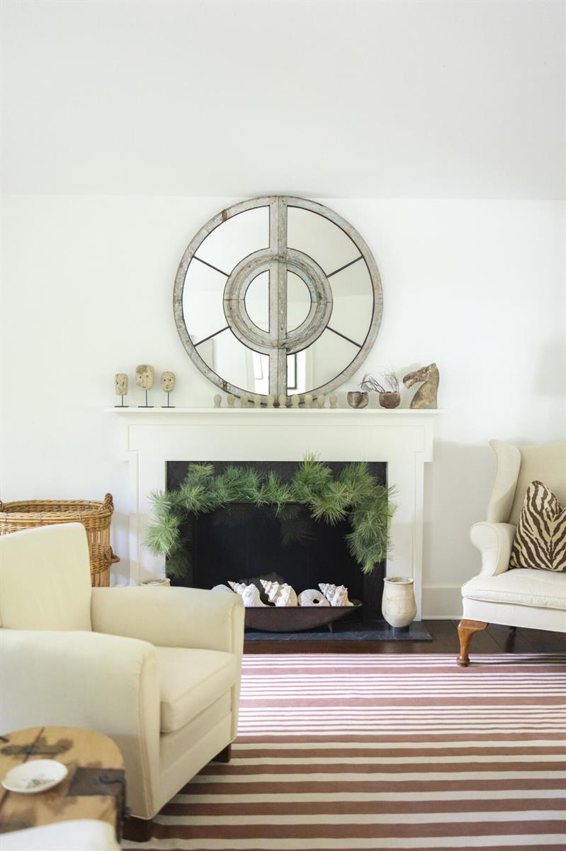 A living room features a white fireplace mantel, a large round mirror, and striped rug — 6880 N Ocean Boulevard # 22, Ocean Ridge FL 33435, OCEAN RIDGE, FL