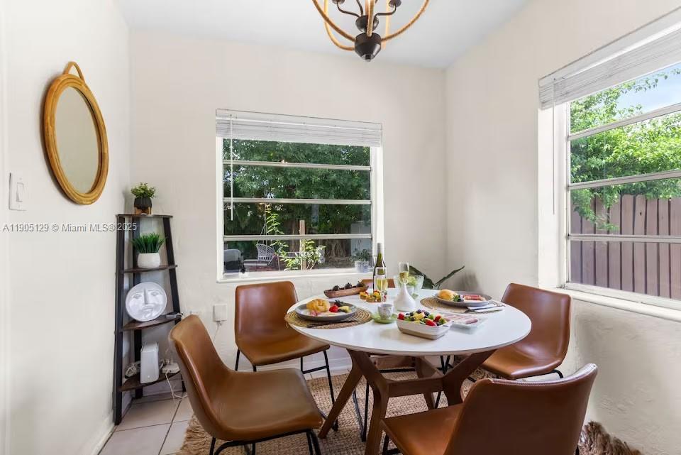 A dining area features a round white table, four brown chairs, and two windows — 402 NW 102nd St, Miami FL 33150, MIAMI, FL