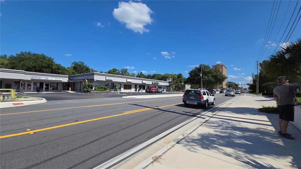 A street-level view shows a commercial strip mall with a parking lot and road — 236 N AMELIA AVENUE, DELAND, FL