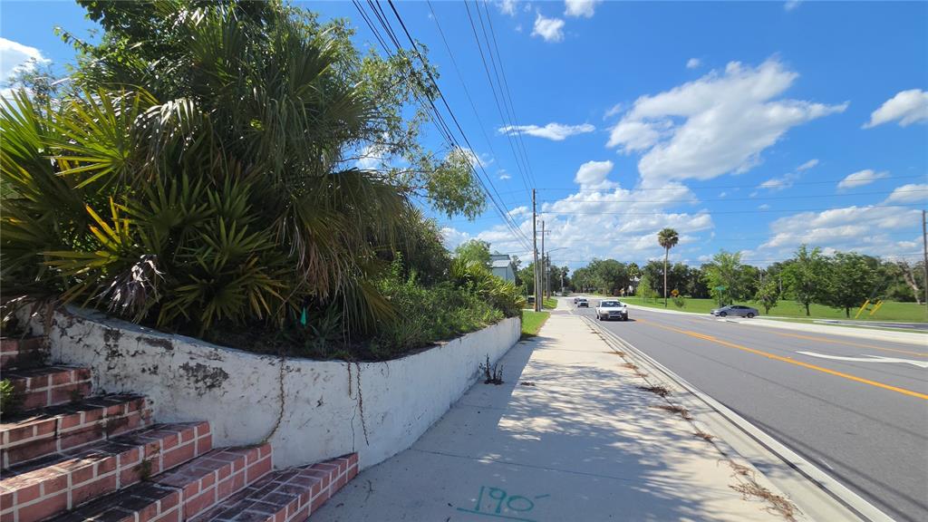A sidewalk runs alongside a road next to a brick staircase and a retaining wall — 236 N AMELIA AVENUE, DELAND, FL