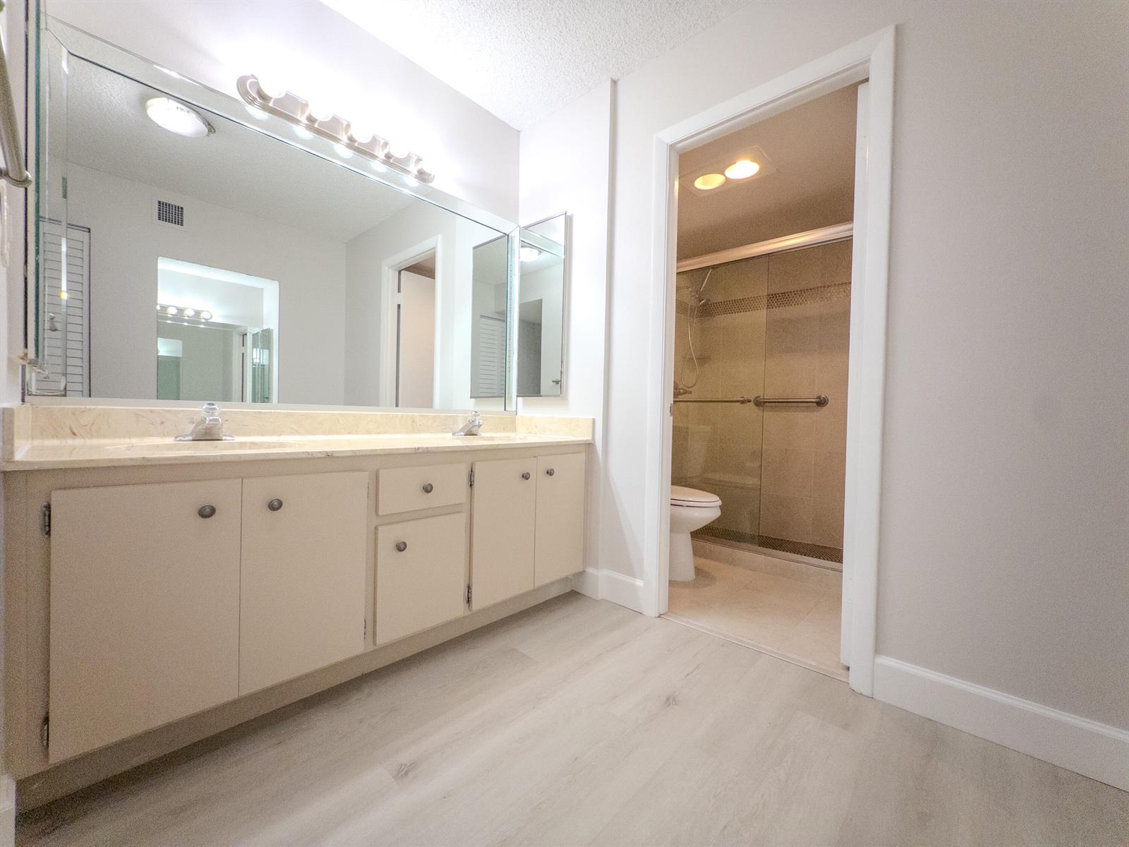 An empty bedroom features light wood-look flooring, white walls, and a ceiling fan — 2800 N 46th # A502, Hollywood FL 33021, HOLLYWOOD, FL