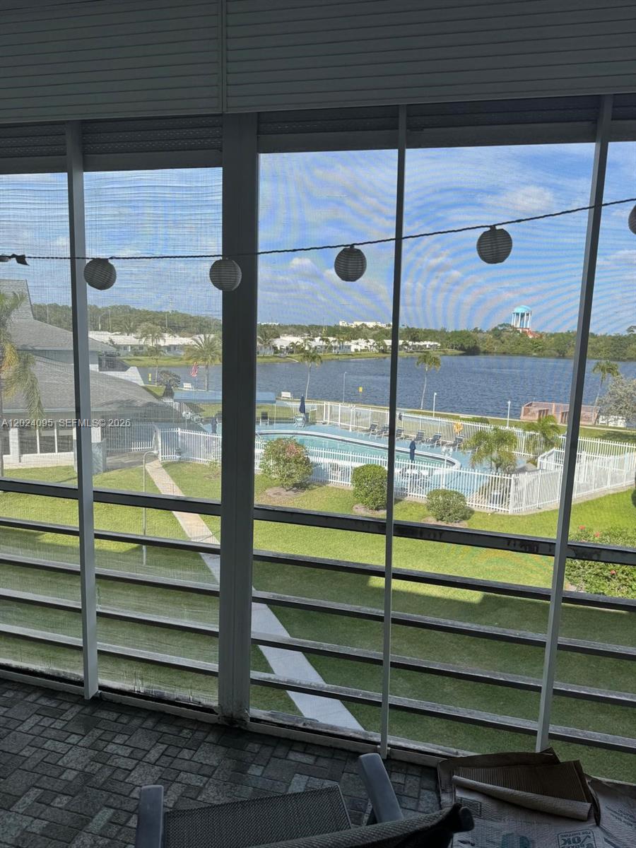 A view of a lake and swimming pool from a screened-in balcony — HOLLYWOOD, FL