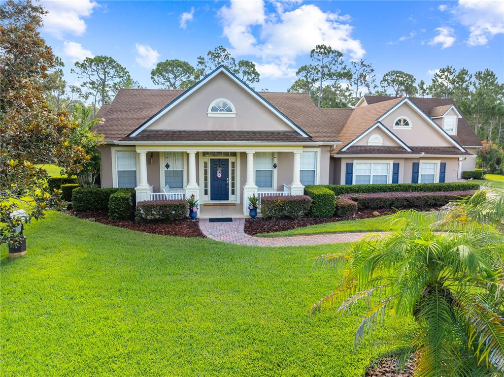 A single-story house with a brick walkway, covered front porch, and a green lawn — 1803 CHARLES COURT, ST CLOUD, FL