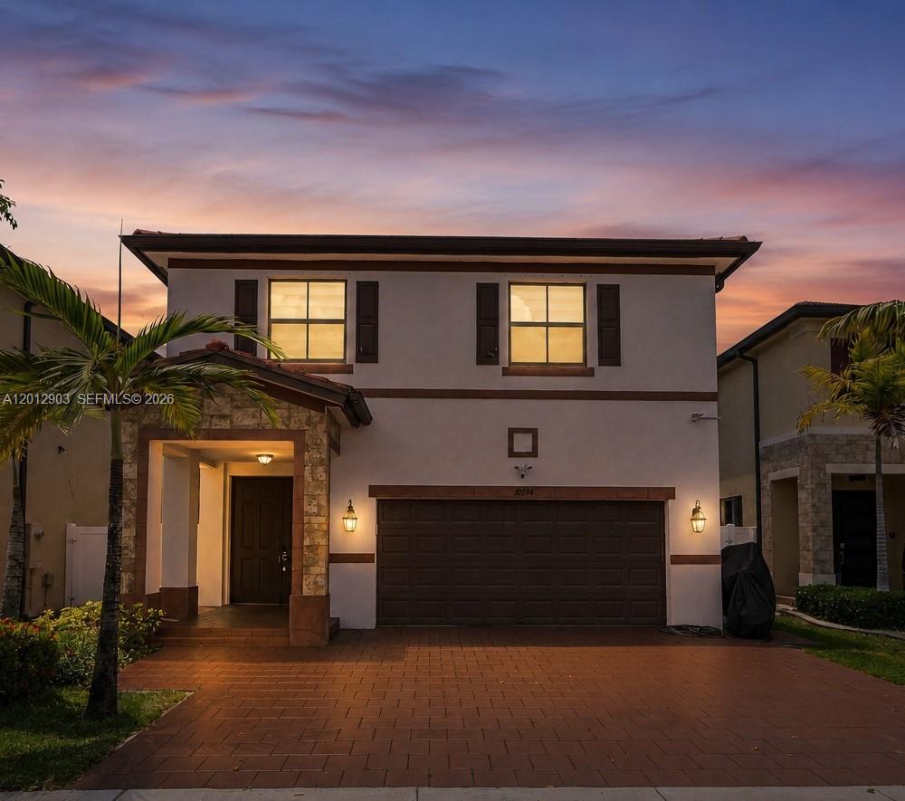 A two-story suburban house with a brown garage door and a paved driveway at sunset — 10594 W 35th Ln, Hialeah FL 33018, HIALEAH, FL