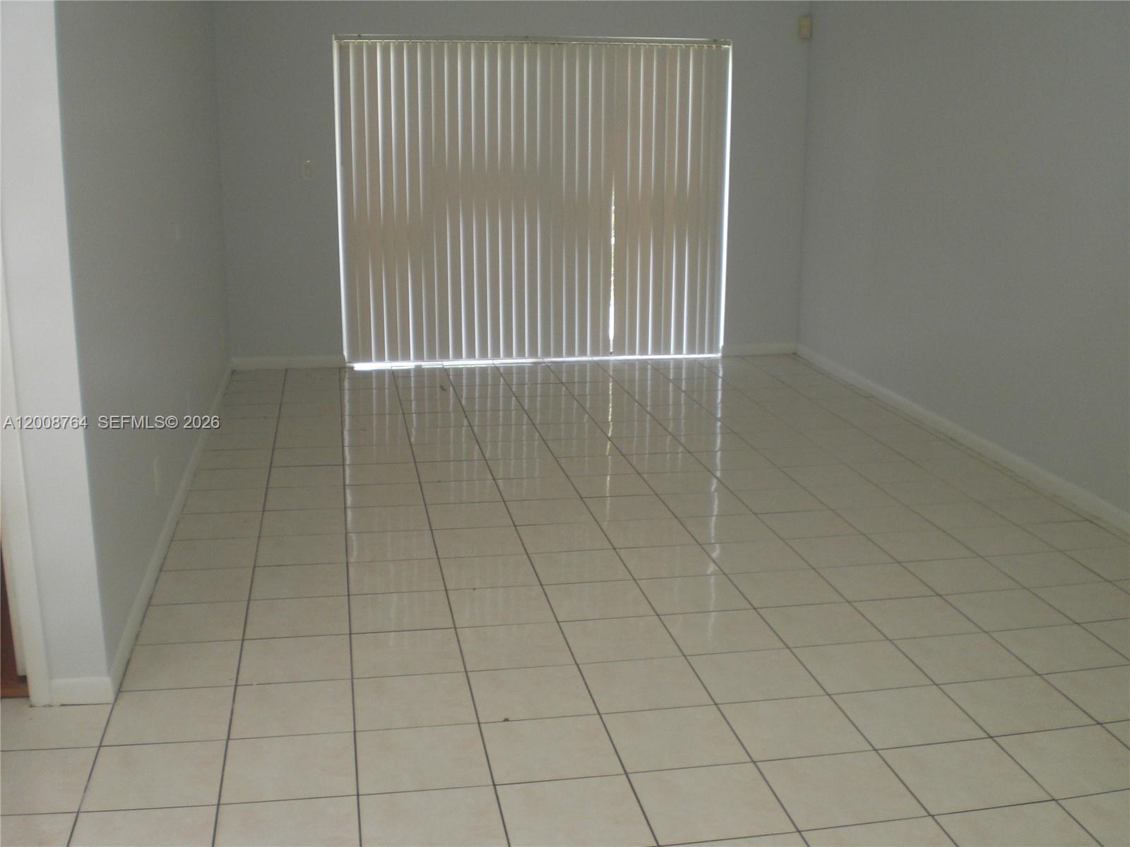 An empty room features light-colored tile flooring and a large sliding glass door with blinds — 962 NW 79th Ter, Plantation FL 33324, PLANTATION, FL