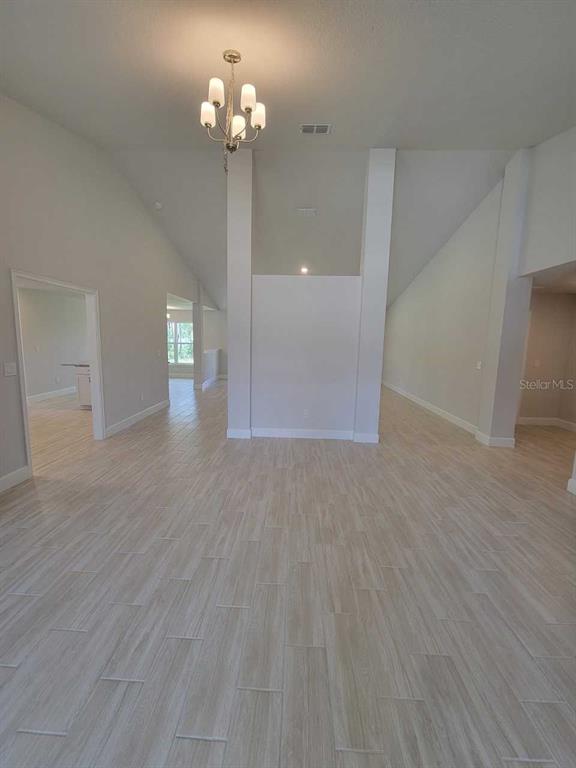 The rear exterior of a single-story house with a covered patio and a large lawn — 12598 SW 73RD STREET, OCALA, FL