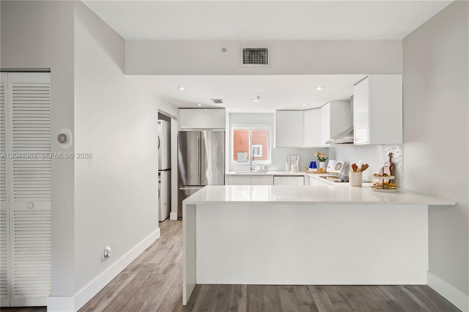 A modern kitchen features white cabinets, a quartz peninsula, and stainless steel appliances — 1611 SW 2nd Ct # A104, Miami FL 33129, MIAMI, FL