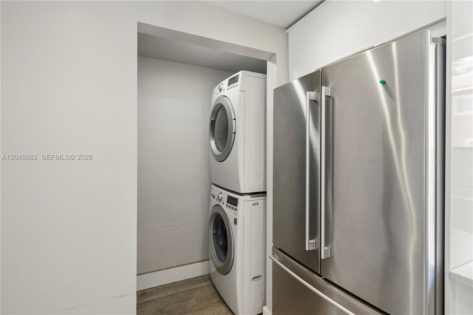 A stacked washer and dryer unit is located in a recessed alcove beside a refrigerator — 1611 SW 2nd Ct # A104, Miami FL 33129, MIAMI, FL