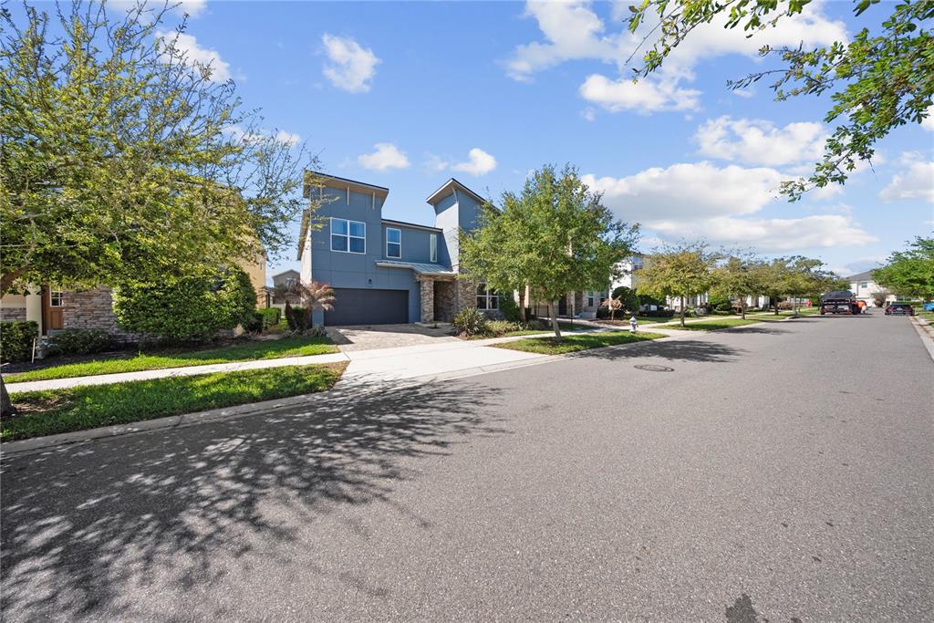 A two-story house with a blue exterior, stone accents, and a paved driveway — 9014 PELICAN COVE TRAIL, KISSIMMEE, FL