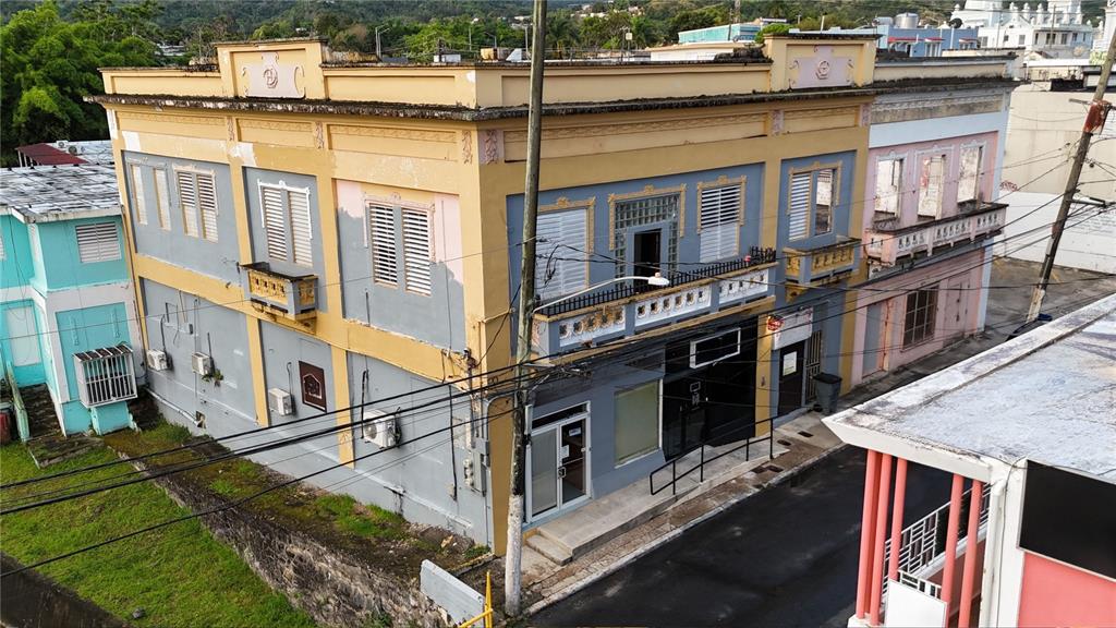 An exterior view of a two-story commercial building with yellow trim and gray walls — 156 CALLE JOSE DE DIEGO, CAYEY, PR