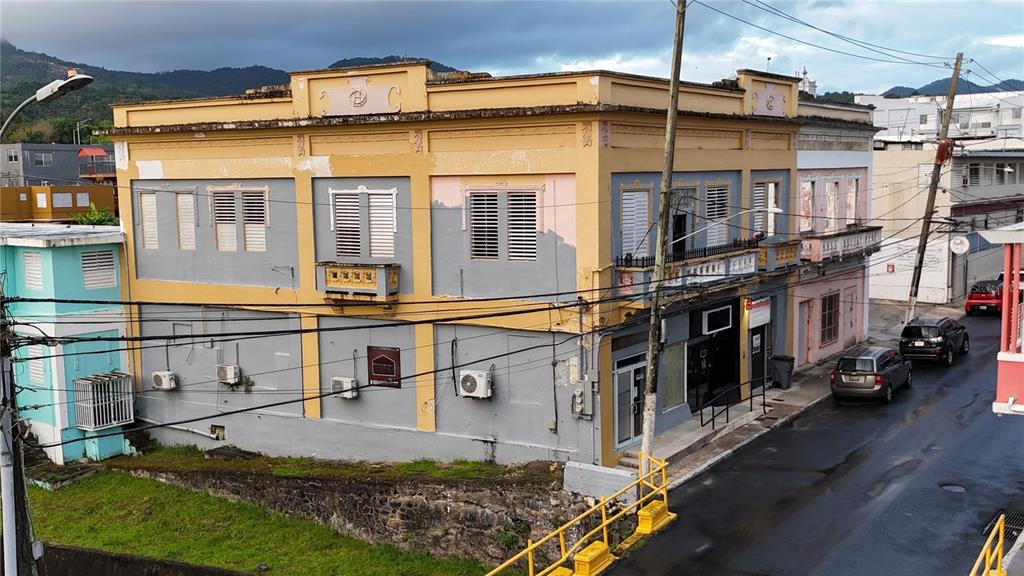 An exterior view of a two-story yellow and gray commercial building on a street corner — 156 CALLE JOSE DE DIEGO, CAYEY, PR