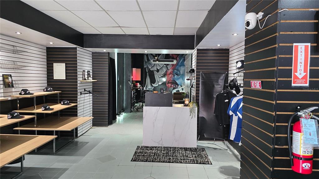 The interior of a retail shop features display shelving, a marble-topped counter, and wall art — 156 CALLE JOSE DE DIEGO, CAYEY, PR